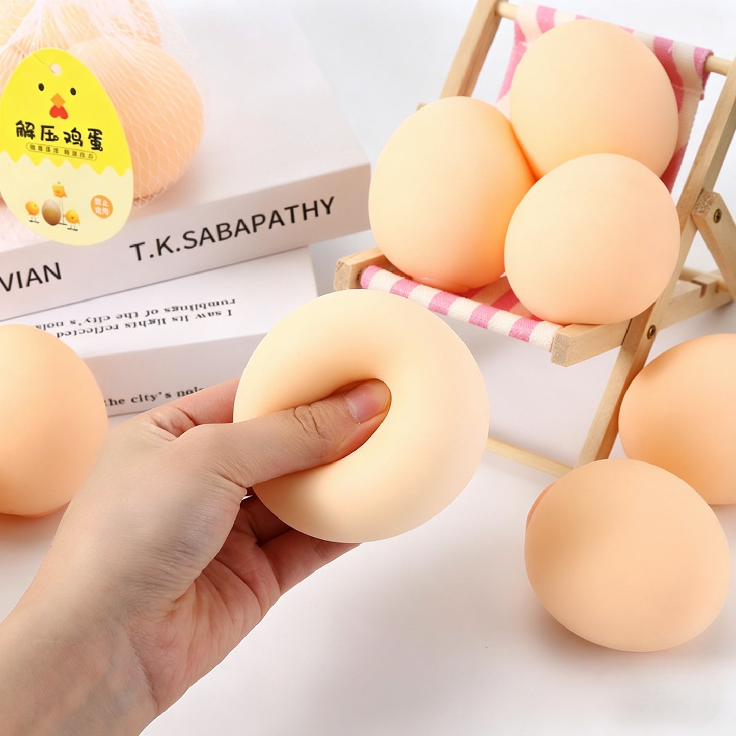 "Hand squeezing and stretching soft egg-shaped squishy toy showing deformation effect"