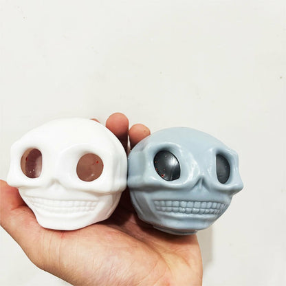 "Hand squeezing skull toy showing popping bead eye effect"