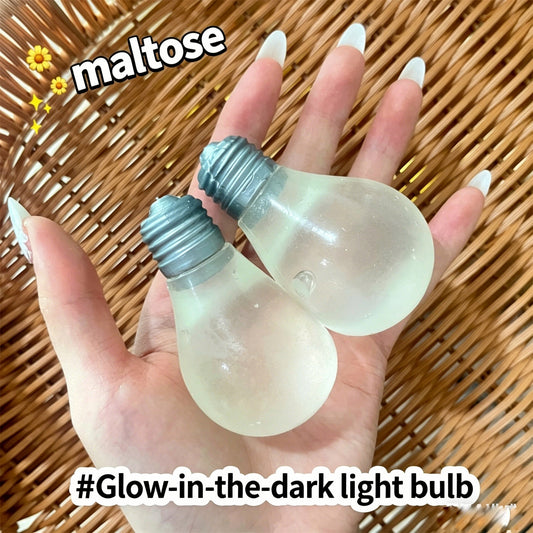 "Hand holding two light bulb-shaped squishy toys daytime and glowing effect"